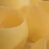 Photophore en cire d'abeille pure avec une flamme dorée, posé sur une étagère décorée de plantes vertes